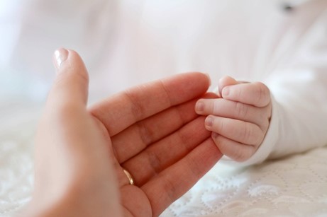 main de bébé qui tient une main d'adulte